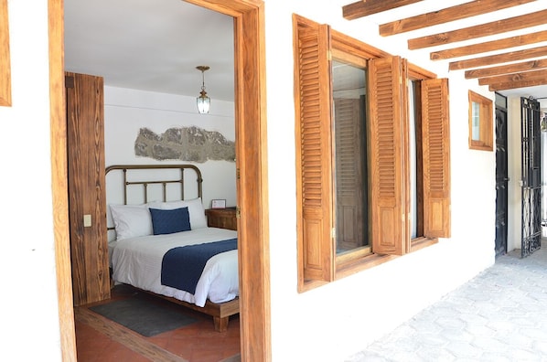 Un dormitorio con cama de madera, mesita de noche y lámpara de pared.
