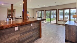 Una cocina amplia con una isla de madera, ventanas grandes y vistas al exterior.