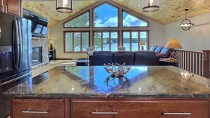 Una cocina amplia con una isla grande, techo de madera y vistas al exterior.