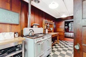 Traditional kitchen with a large stove, sink, and wooden countertop.