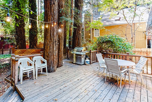Enjoy al fresco dining on the deck, surrounded by lush trees and a barbecue grill.