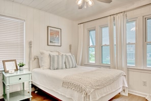 A bedroom with a bed, a nightstand, a ceiling fan, and a window with curtains. - Sunny, dog-friendly beach house with a washer/dryer, central AC, & deck (North Myrtle Beach)