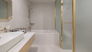 A modern bathroom with a large bathtub, a separate shower area, and a glass-enclosed walk-in shower.