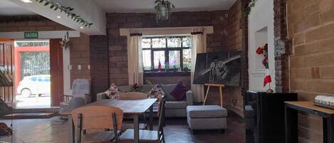 Ein geräumiger Essbereich mit Holztisch und -stühlen, einer Couch und einem Bild an der Wand.