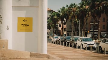 Un área de estacionamiento con un letrero amarillo que indica el camino a recepción y al segundo piso del Mon Hotel.