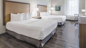 A hotel room with two beds, a desk, and a chair. - La Quinta Inn & Suites by Wyndham Valdosta (Valdosta)
