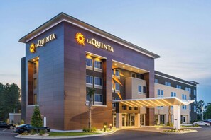 A La Quinta hotel with a modern design, featuring a prominent entrance and a covered outdoor area. - La Quinta Inn & Suites by Wyndham Valdosta (Valdosta)