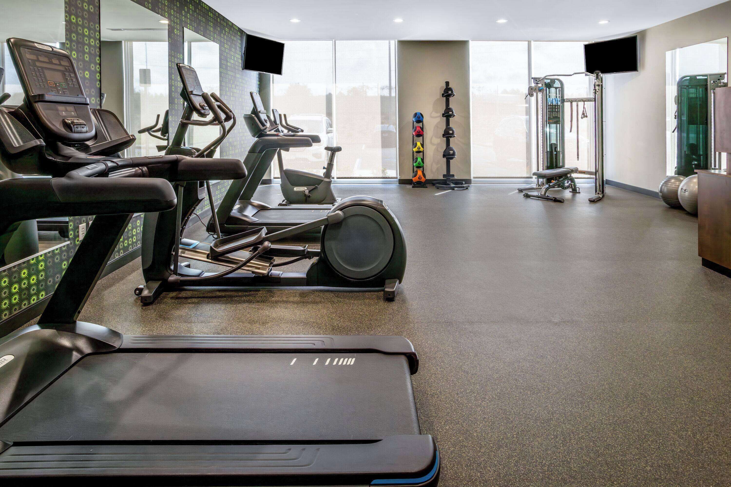 A gym with treadmills, ellipticals, and weight equipment.