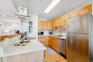 A modern kitchen with wooden cabinets, stainless steel appliances, and a wooden countertop. - Downtown loft + studio with water/city views, 2 full kitchens, & free WiFi (Port Angeles)