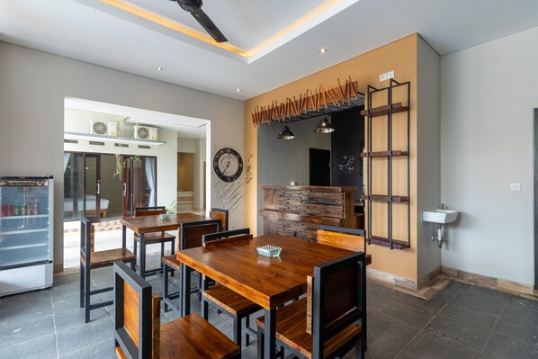 Un comedor moderno con una mesa y sillas de madera, un banco empotrado y un estante fijado a la pared.
