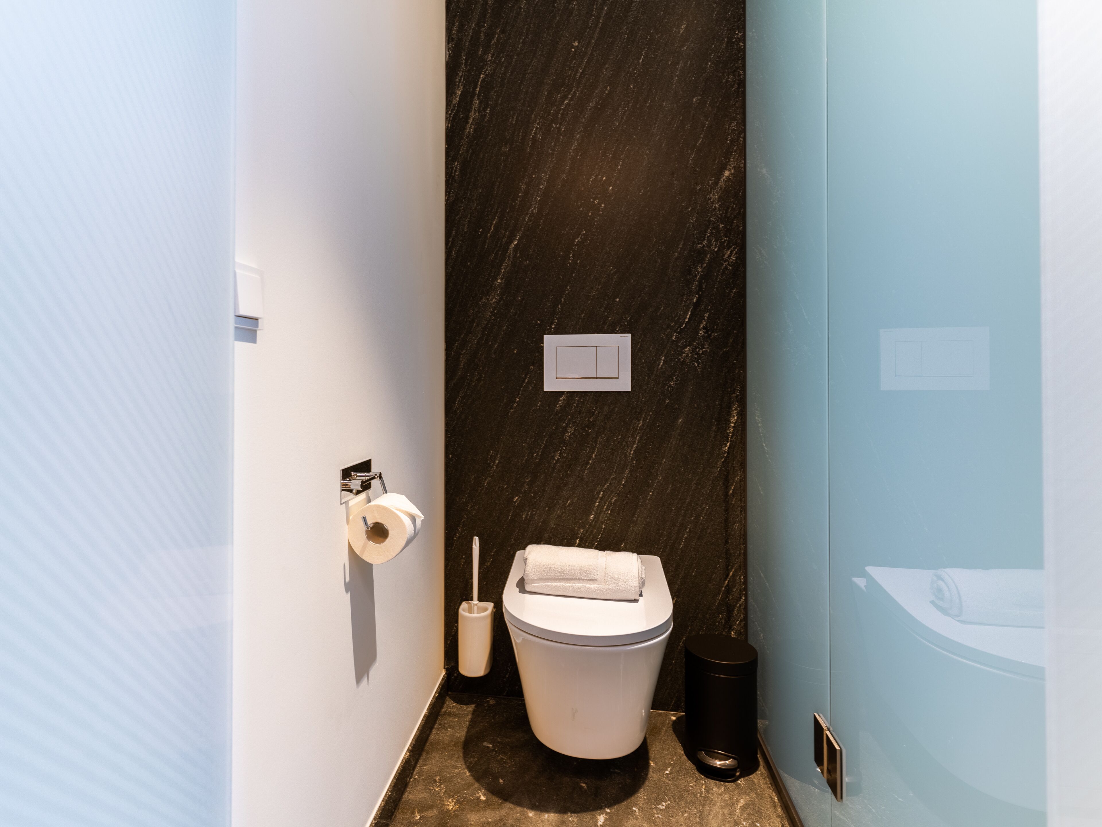 Un baño pequeño con inodoro, bidé y un cubo de basura.