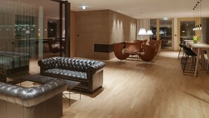 Un intérieur moderne avec un canapé en cuir, une table à manger en bois et des chaises contemporaines.