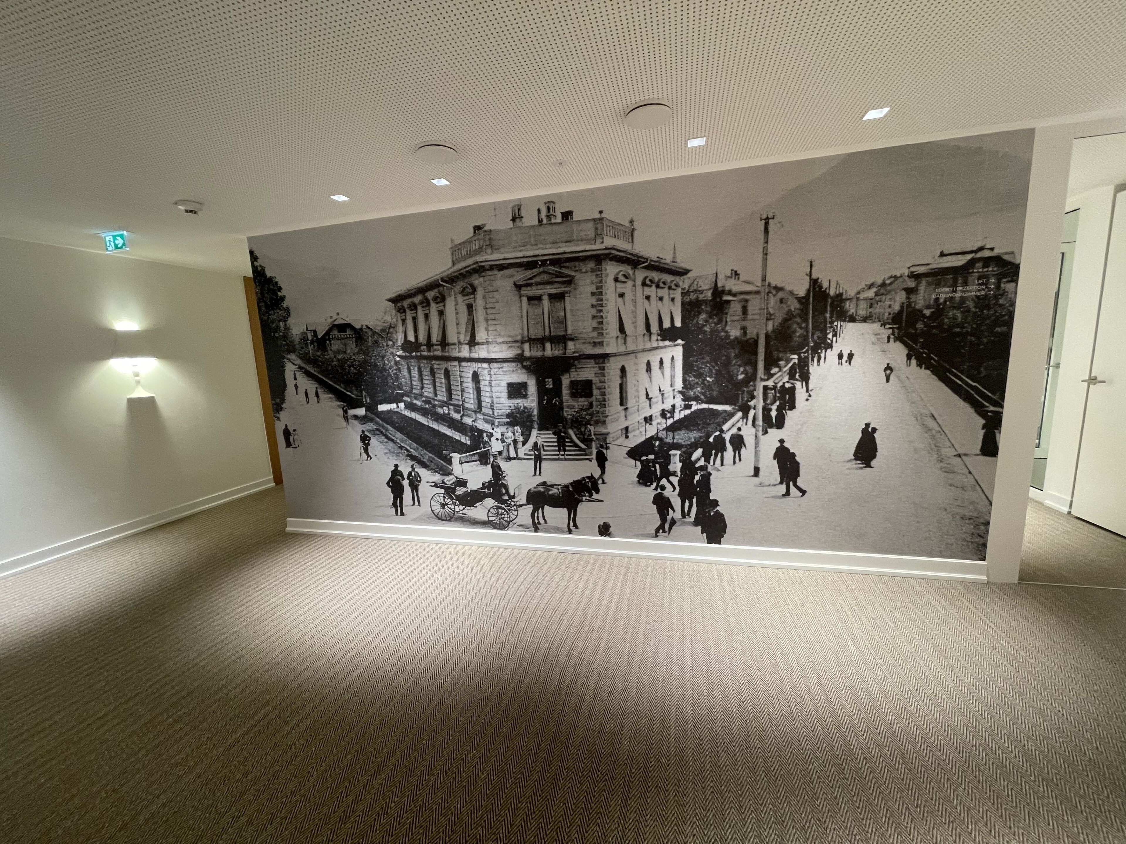 A hallway with a large mural depicting a historical street scene.