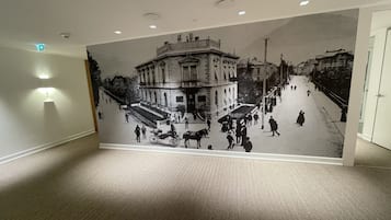 A hallway with a large mural depicting a historical street scene.