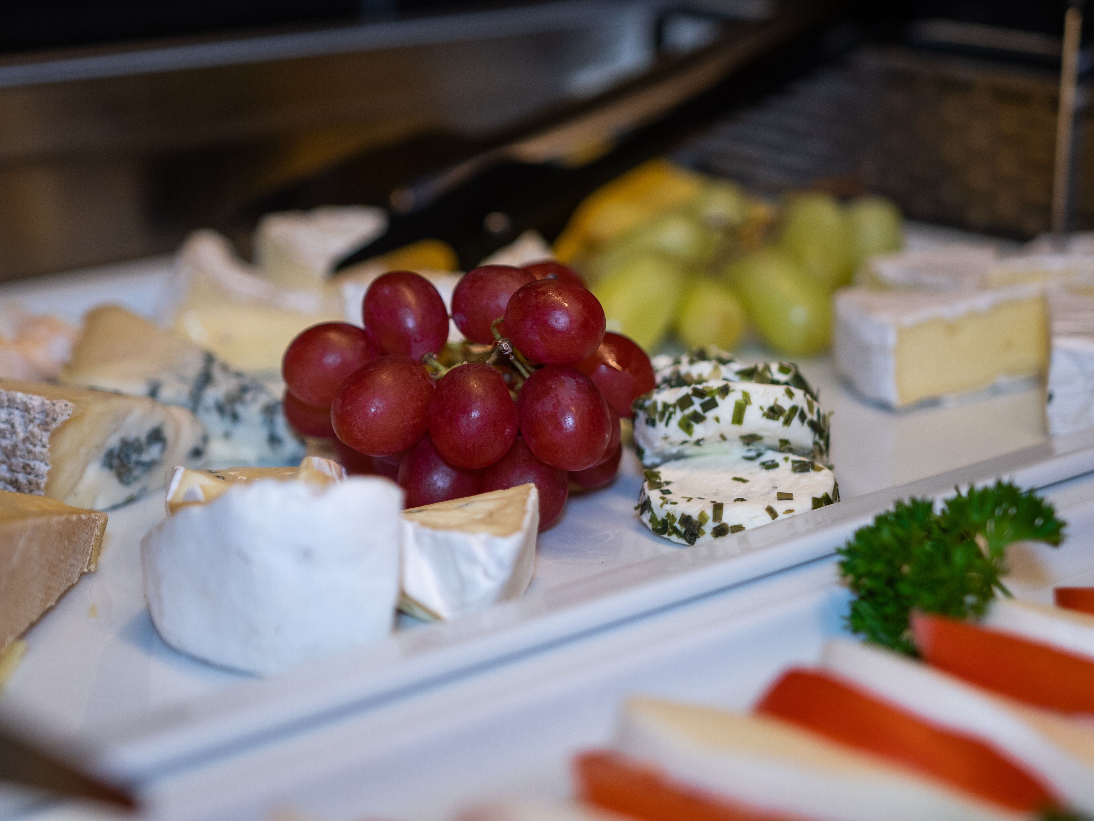 Une variété de fromages et de raisins présentés sur un plateau.
