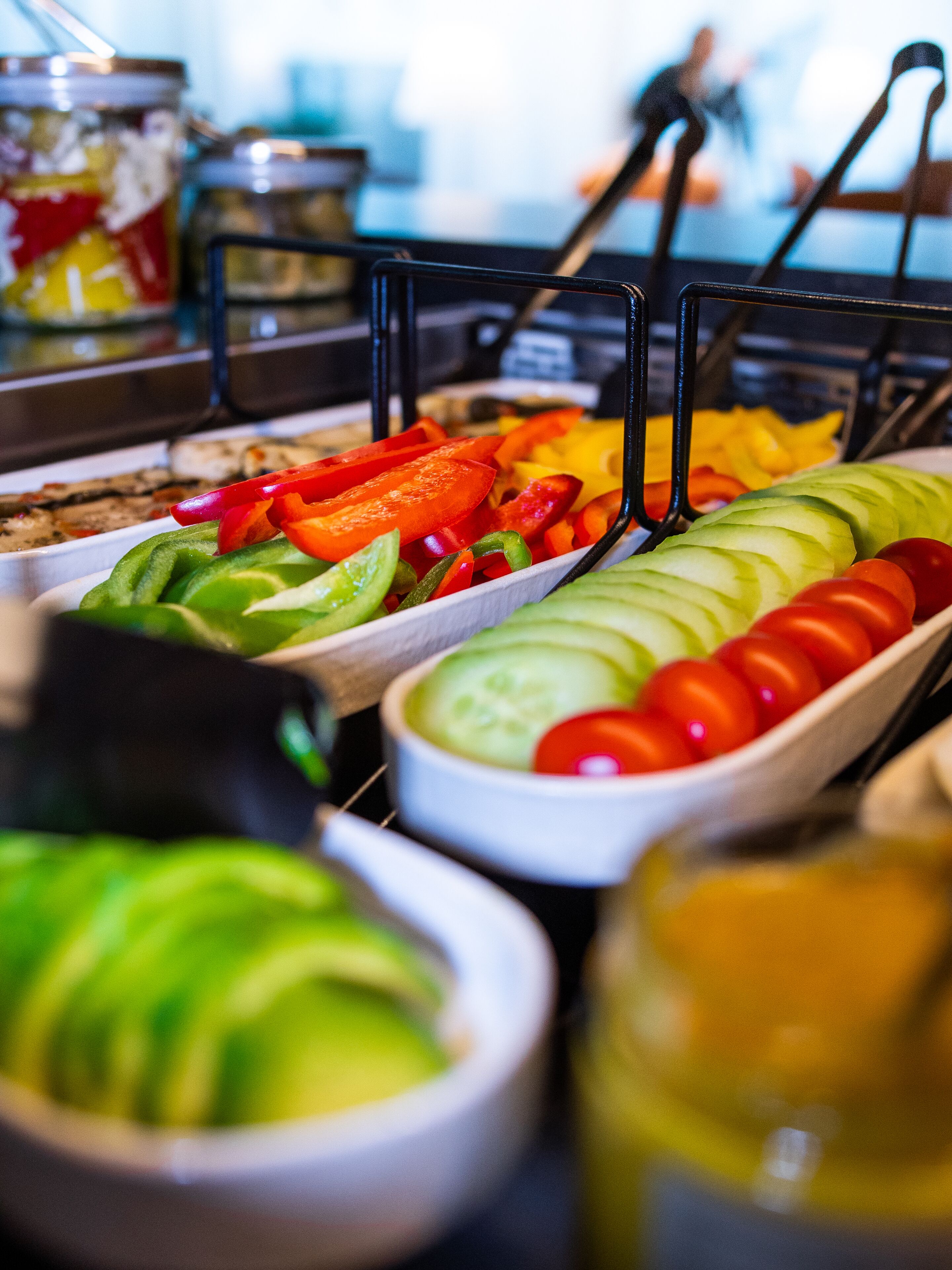 A buffet with various sliced vegetables and fruits.