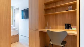 Une chambre moderne avec un bureau en bois, une chaise, une télévision et un lit.