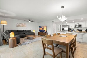 Un salon moderne avec un canapé, une table basse et une table à manger avec des chaises.