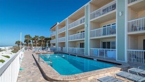 Ein Hotel mit Pool, mehreren Balkonen und Blick auf den Strand.