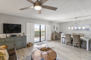 Relax in a spacious living area with a large flat-screen TV, comfortable seating, and a dining space.