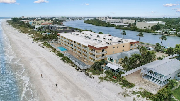Luchtbeeld van een strandhotel met meerdere gebouwen, een zwembad en een rivier in de buurt.