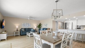 A modern living room with a dining area, a kitchen, and a ceiling fan. - 🌊 Beachfront 2BR Condo with Direct Pool Access – Steps to the Sand, Sleeps 6 (Indian Rocks Beach)