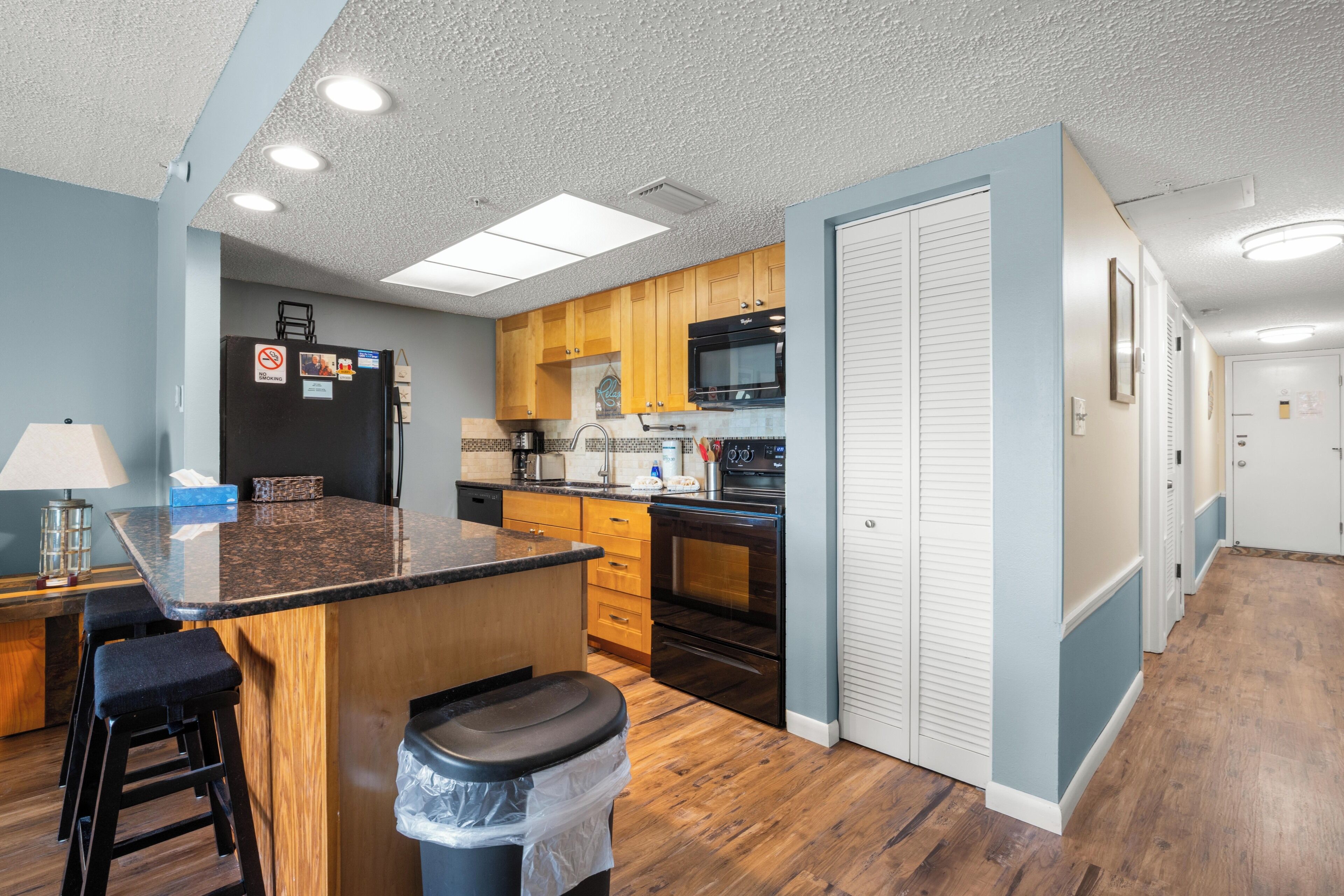 A kitchen with wooden cabinets, a microwave, and a stove.