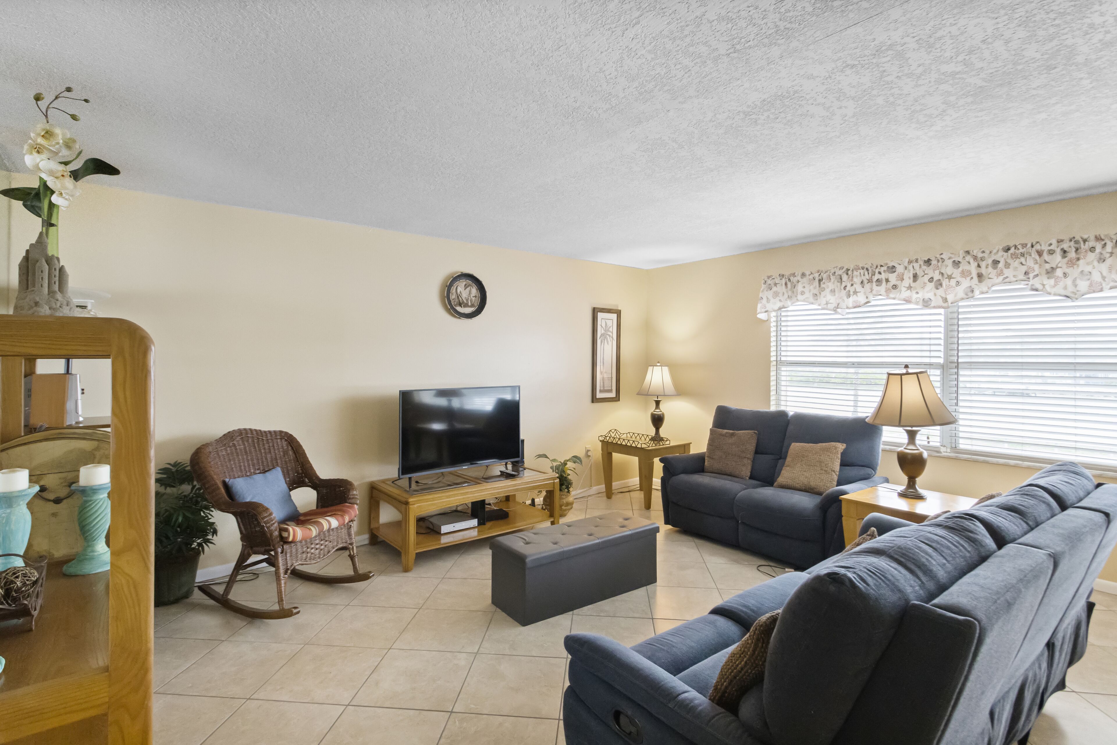 A living room with a television, sofas, a coffee table, and a lamp.
