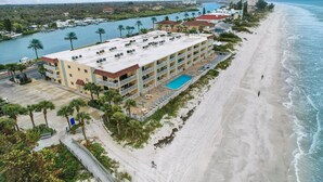 A hotel with a pool, beachfront view, and multiple balconies. - Remodeled 1BR Intracoastal View Condo – Designer Touches, Balcony, & Serene Waterway Setting (Indian Rocks Beach)