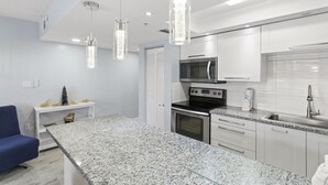 A modern kitchen with granite countertops, stainless steel appliances, and pendant lighting. - Remodeled 1BR Intracoastal View Condo – Designer Touches, Balcony, & Serene Waterway Setting (Indian Rocks Beach)