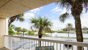 A balcony with a view of a parking lot and a body of water. - 🌅 Modern 2BR Intracoastal View Condo – Sunrise Balcony & Serene Comfort on Indian Rocks Beach (Indian Rocks Beach)