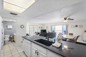 Enjoy cooking in this well-equipped kitchen with a sink, refrigerator, and dining area.