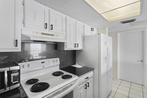 Enjoy cooking in this well-equipped kitchen with a microwave, stove, and refrigerator.