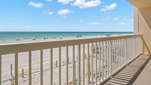 A beach view from a balcony with a white railing, clear sky, and calm sea. - Coastal Charm & Sunset Views from Your Beachfront Balcony at Fifty Gulfside – Indian Rocks Beach (Indian Rocks Beach)