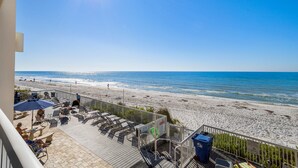 A balcony with a view of a beach and ocean.