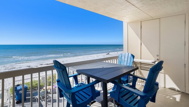 A balcony with a view of the beach and ocean.