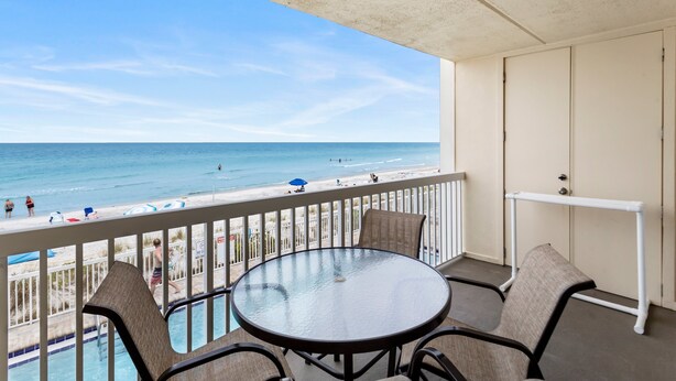 Ein Balkon mit Blick auf Strand und Meer.