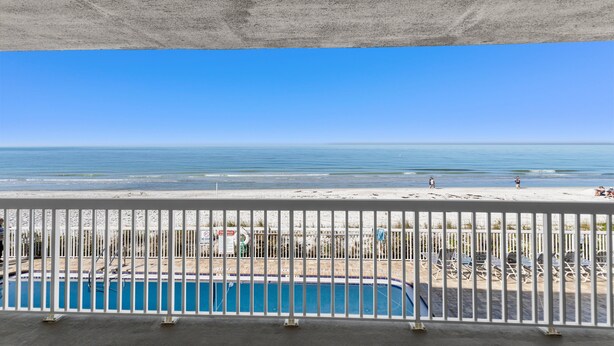 Un espace piscine offrant une vue sur la plage et l’océan.
