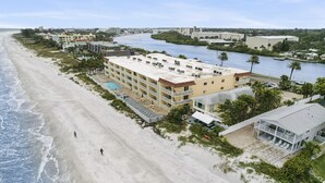 Un hotel sulla spiaggia con diversi balconi, una piscina e vista sulla spiaggia e sul fiume.