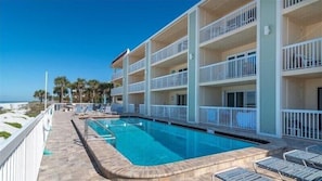 Un hotel con piscina, varios balcones y vista al mar.