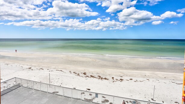 Een strand met een heldere lucht en rustige zee.