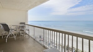 Een balkon met uitzicht op het strand en de oceaan.