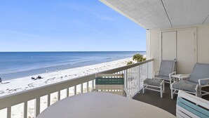 Ein Balkon mit Blick auf Strand und Meer.