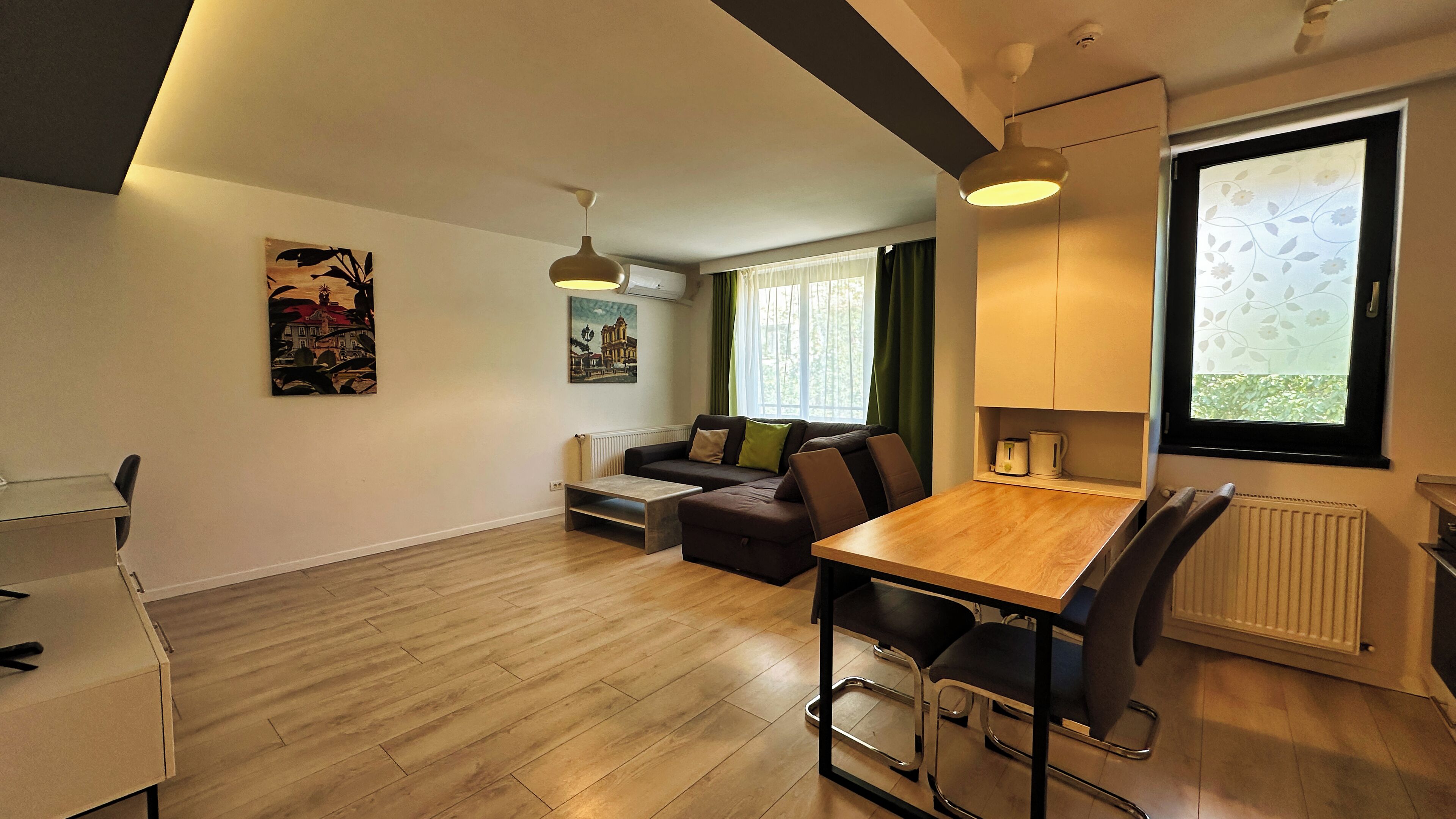 A modern living room with a sofa, a dining table, and a coffee machine.