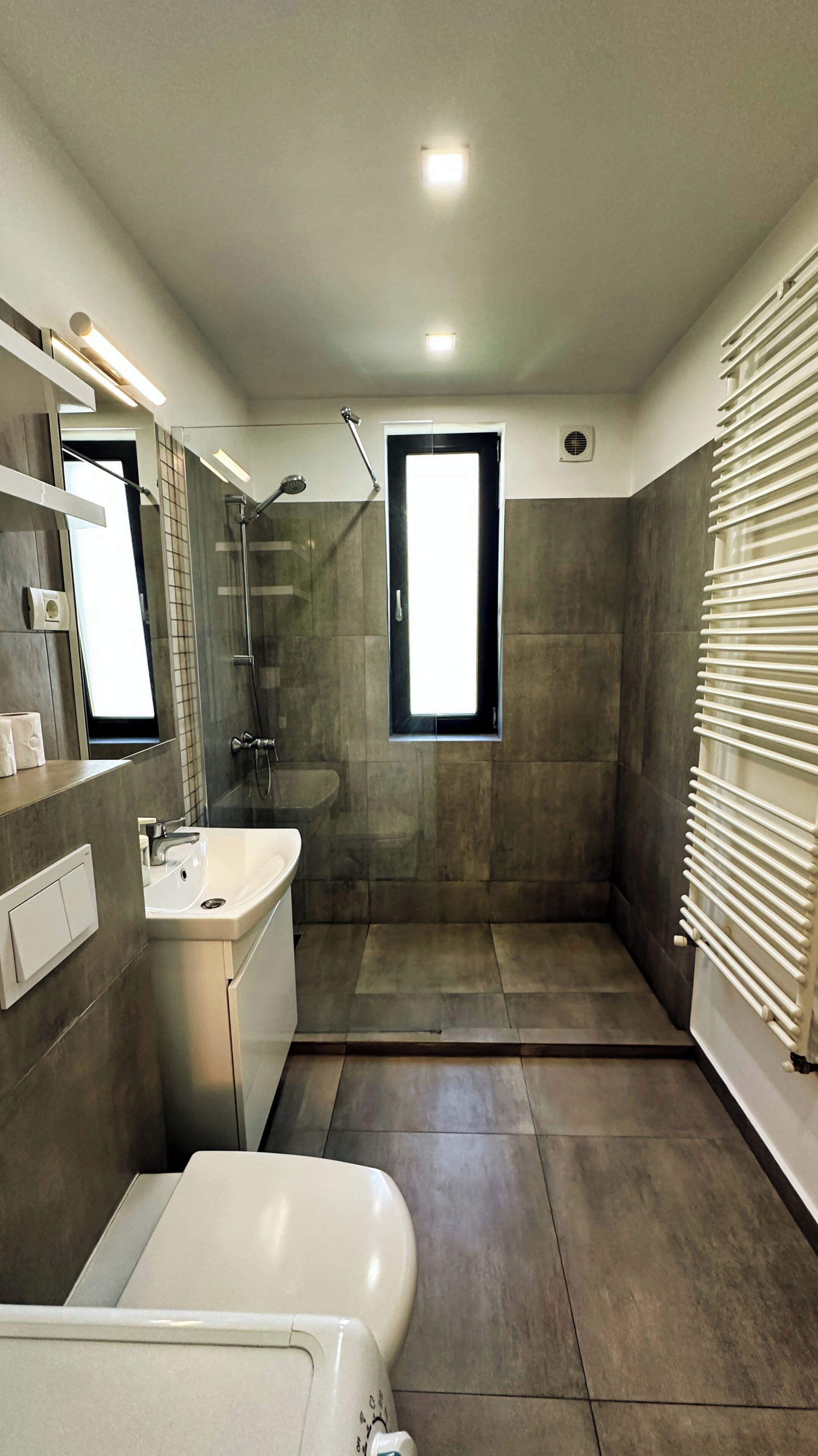 Un baño moderno con bañera, lavamanos y zona de ducha.
