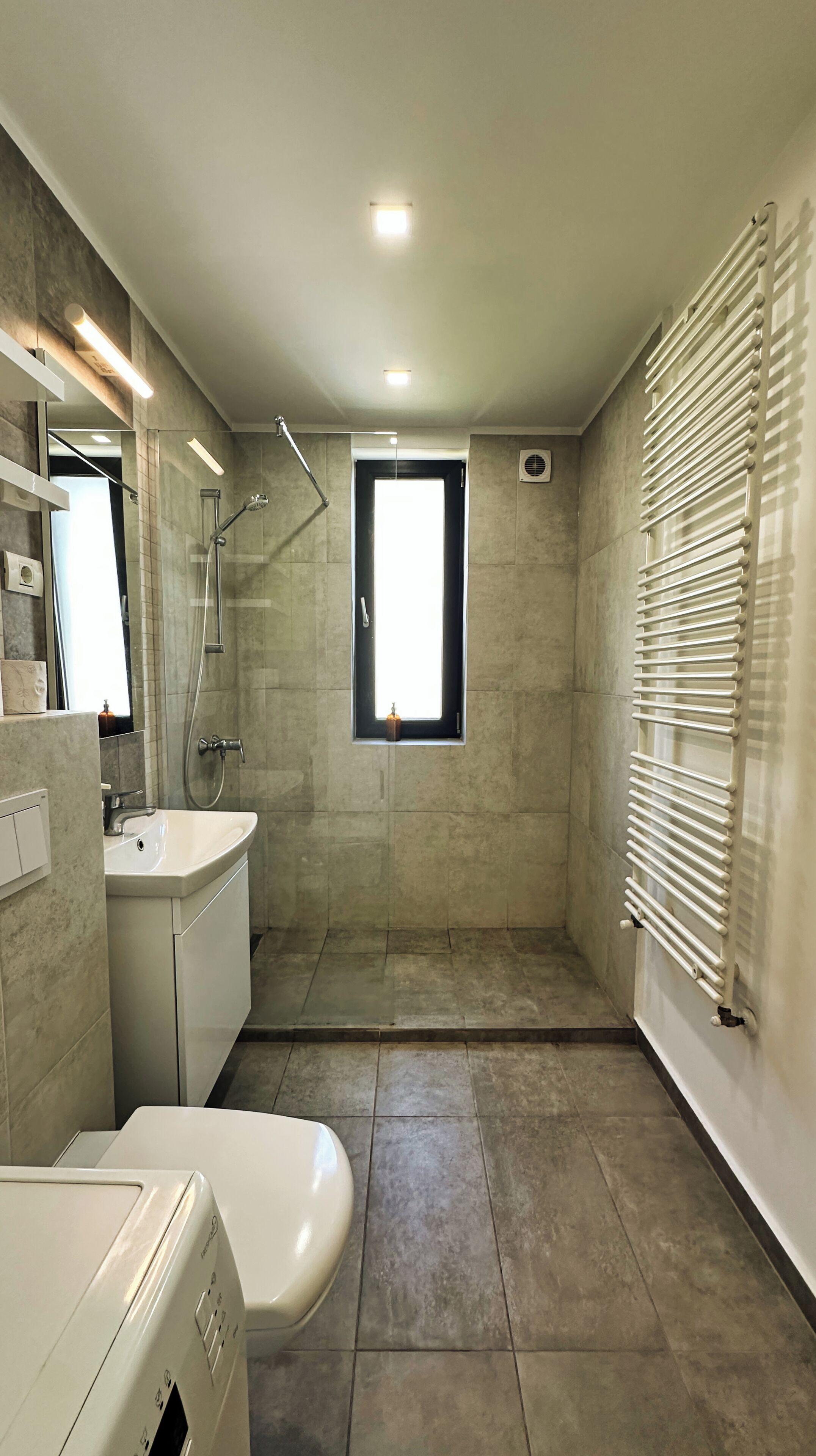 Un baño moderno con ducha, inodoro y lavamanos.