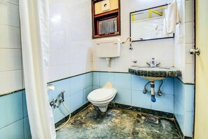 A bathroom with a toilet, sink, and shower.