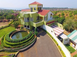 A multi-story building with a central courtyard, a swimming pool, and a red-roofed annex.