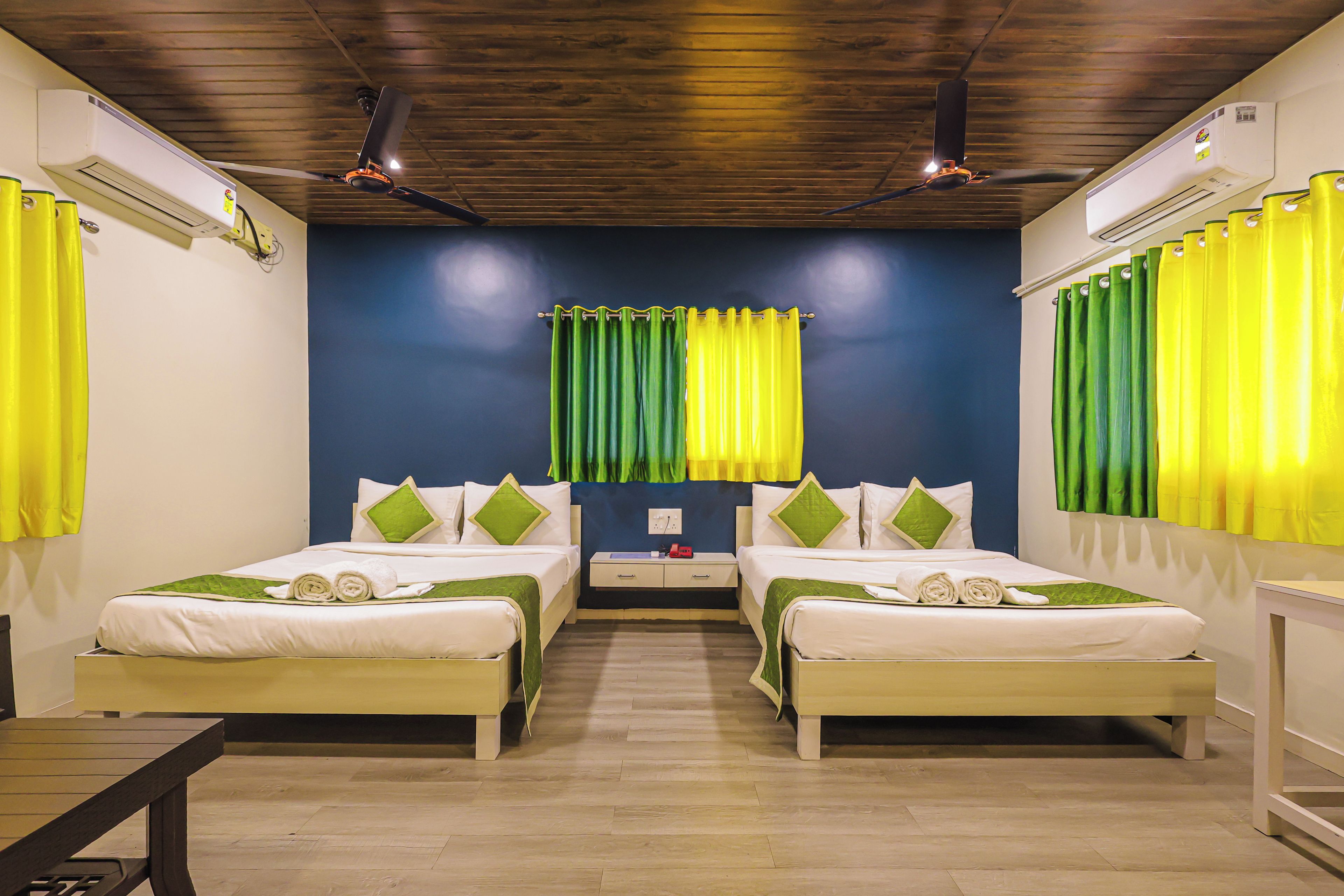 A hotel room with two beds, a wooden ceiling, and curtains.