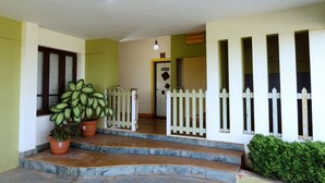 A staircase leading to a door with a white picket fence. - Kokanwadi Resort (Ratnagiri)